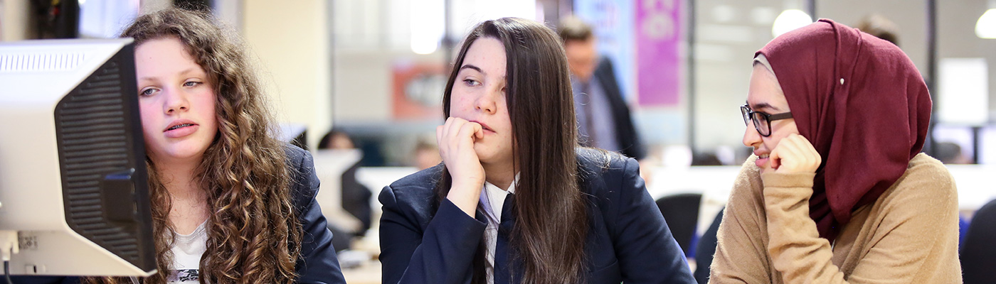 Three female school students using a computer