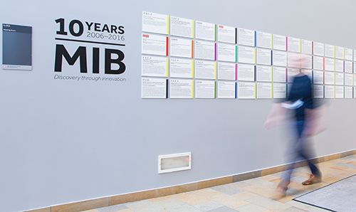 A researcher walking past the MIB logo