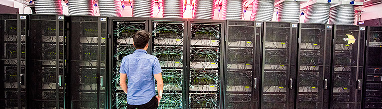A male student standing in front of the Human Brain computer